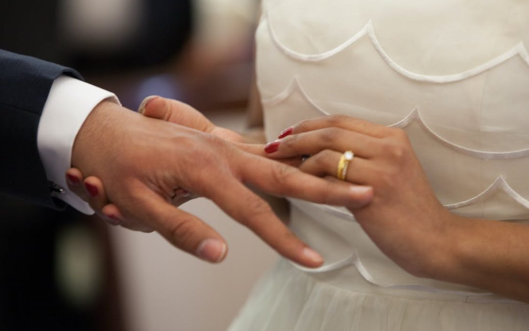 Bride Putting a Ring on Grooms Hand